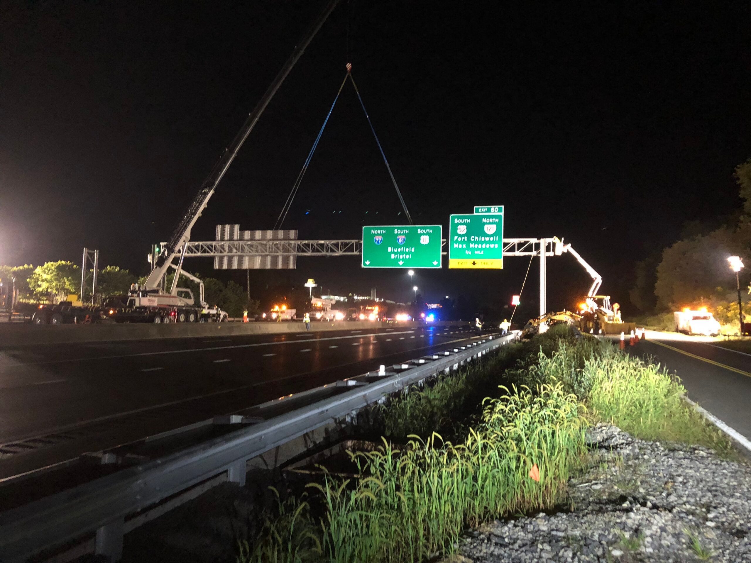W-L crew installing an overhead interstate guide sign at night